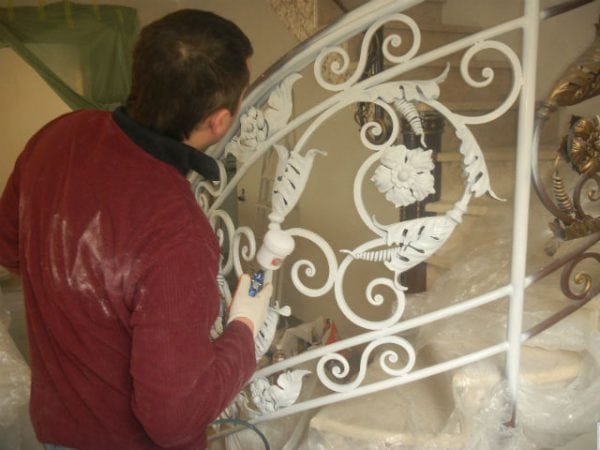 A man paints a forged product