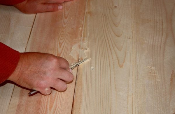 A man spits on a wooden floor