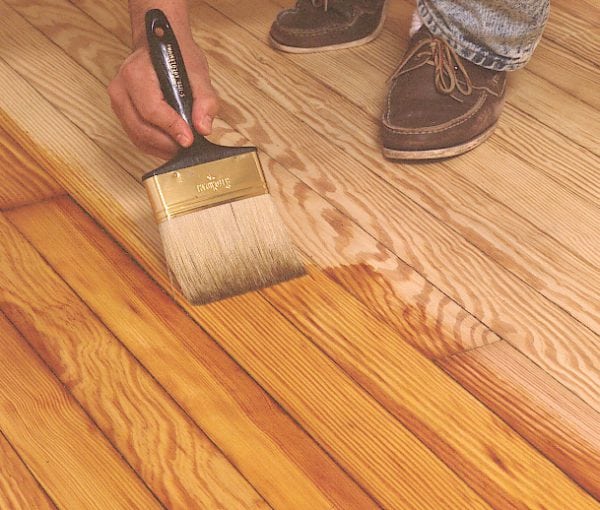 Apply varnish with a brush on the floor