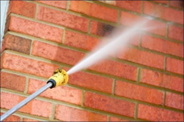 Cleaning a brick with a jet of water