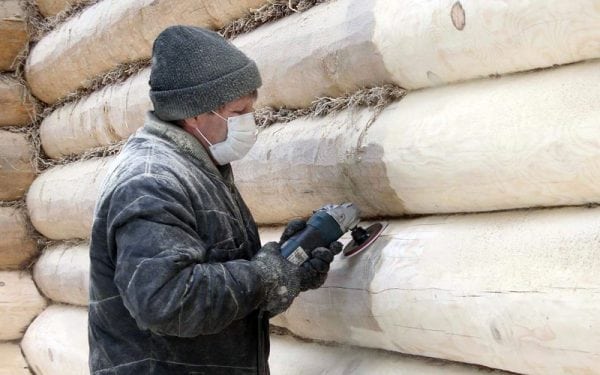 Grinding a log house with a manual grinder