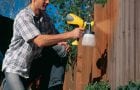 Painting a fence with a spray gun