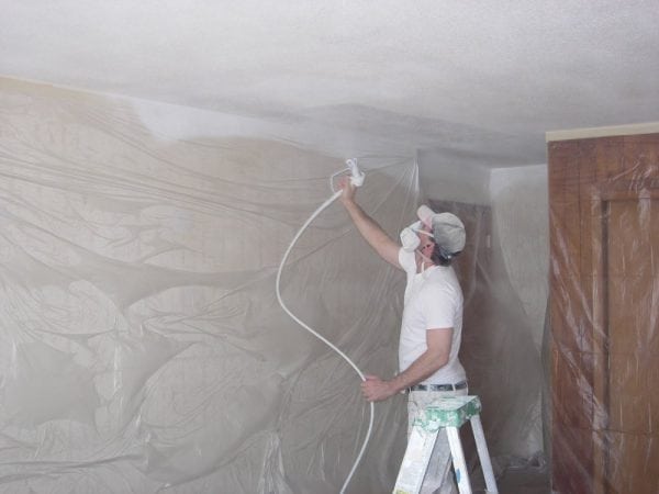 The process of applying paint to the ceiling with a spray gun