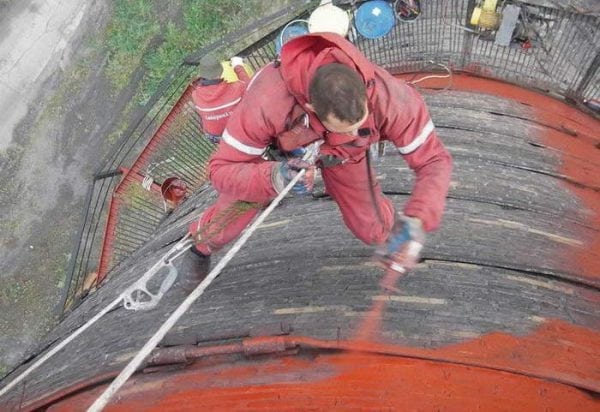 The process of painting the chimney with a spray gun