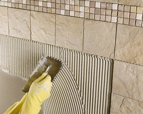 Apply tile adhesive to the wall