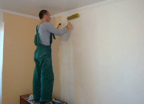 Glue for non-woven wallpaper is applied to the wall