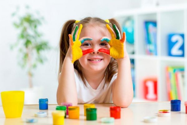 The child draws with finger paints