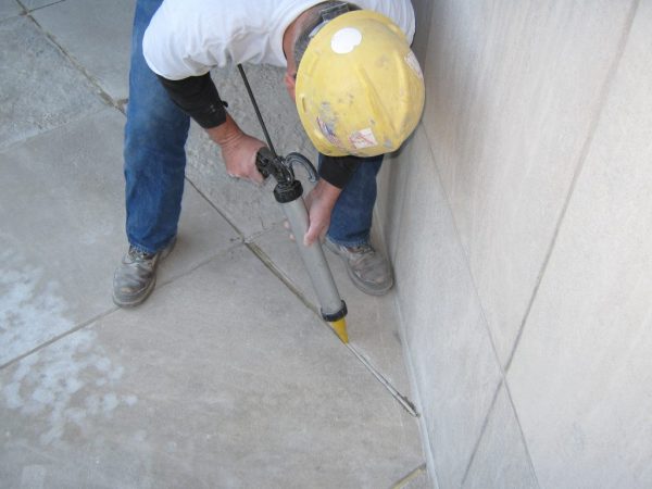 Filling joints in a concrete floor from a construction syringe