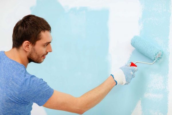 Putting blue paint on the wall